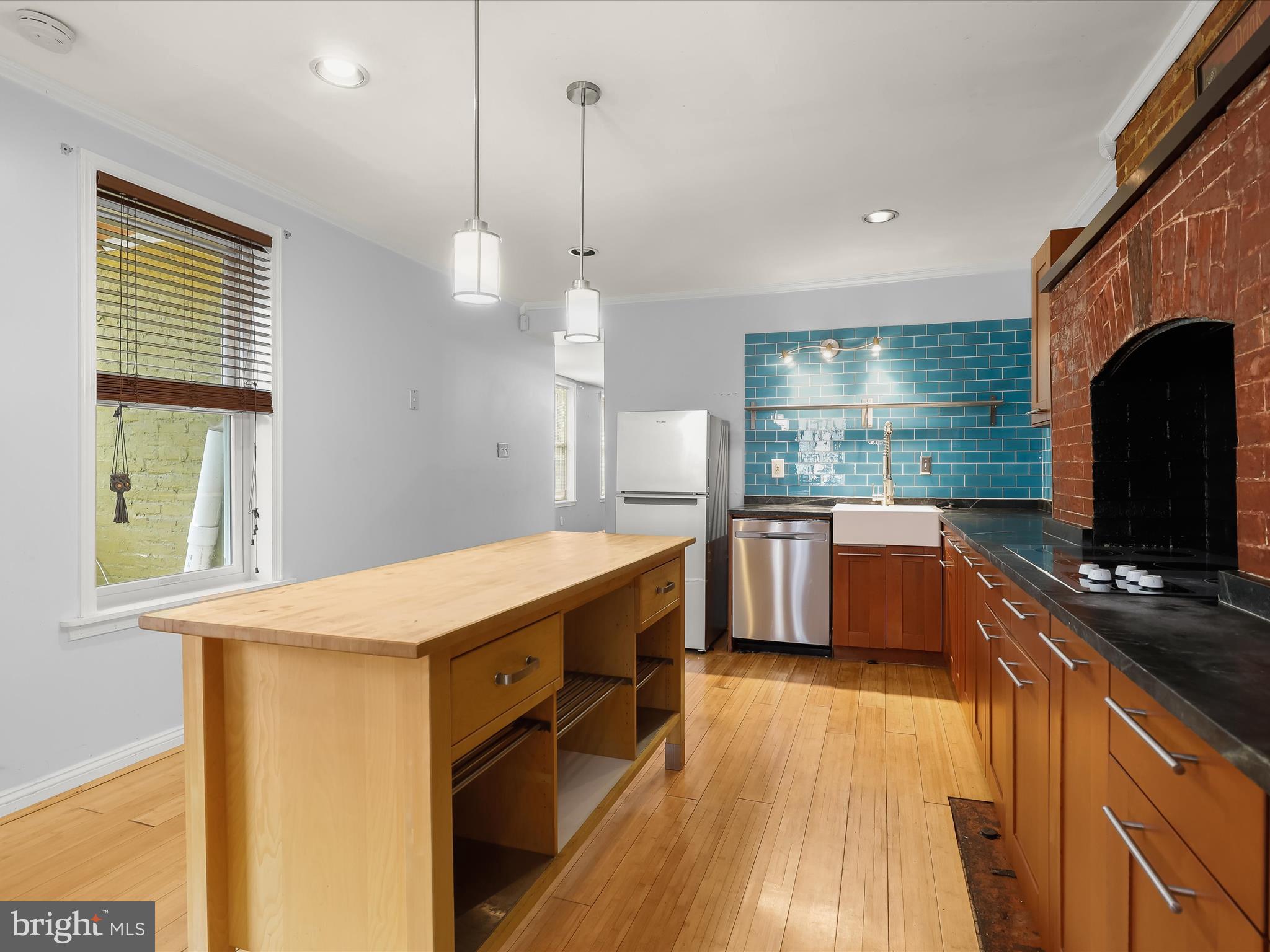 55 South Fulton Avenue Baltimore, MD 21223 - Photo 6 of 55 a kitchen with stainless steel appliances granite countertop a sink a stove and a wooden floors