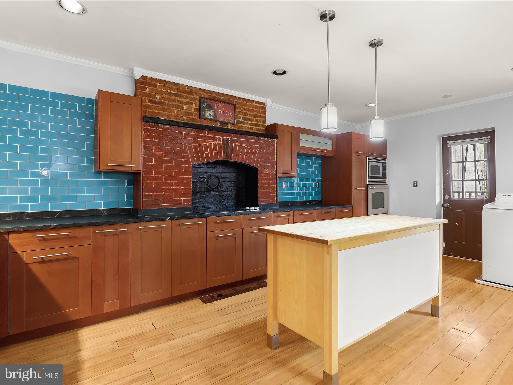 55 South Fulton Avenue Baltimore, MD 21223 - Photo 9 of 55 a kitchen that has a sink a microwave oven a stove and white cabinets
