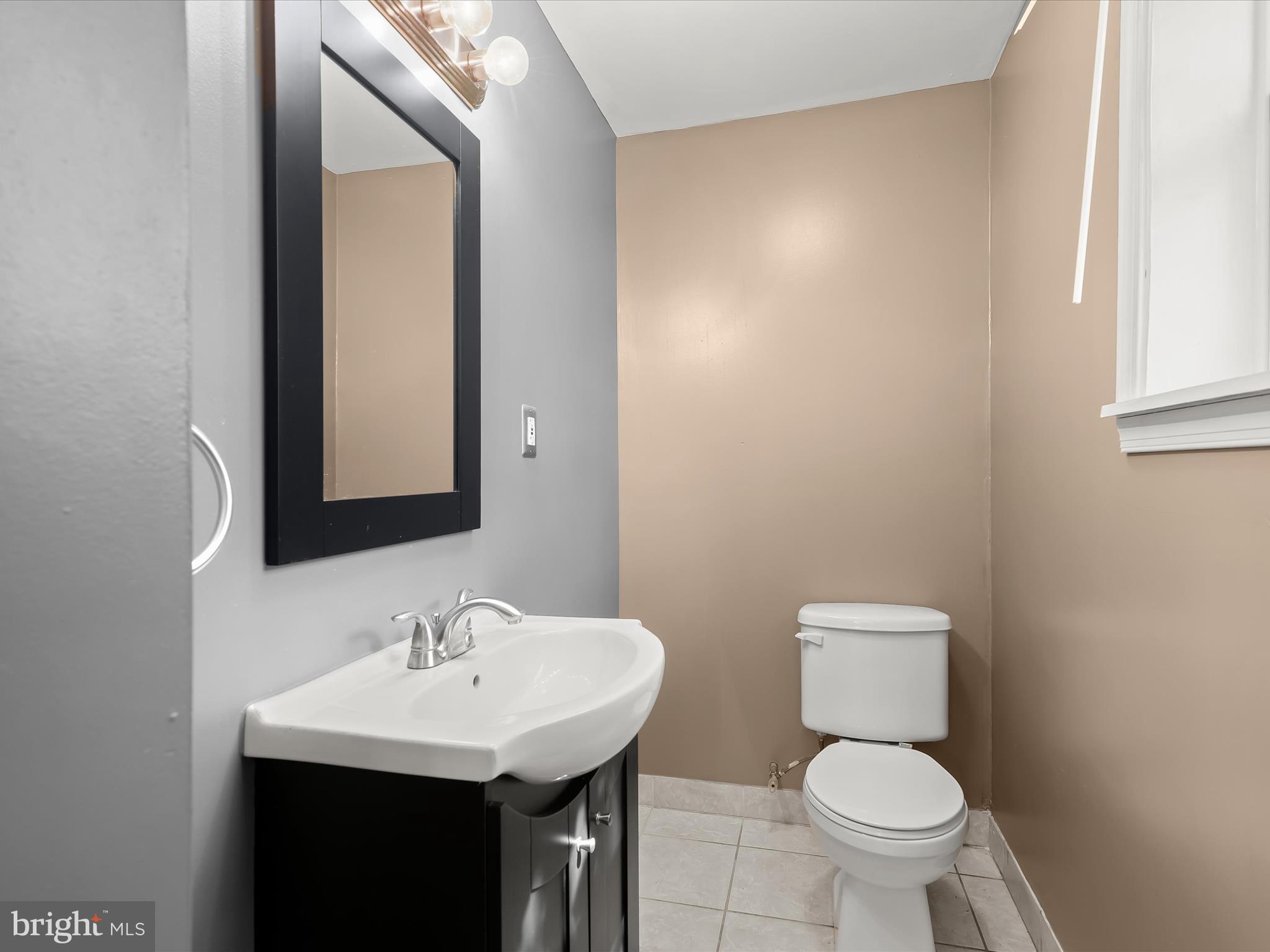 55 South Fulton Avenue Baltimore, MD 21223 - Photo 13 of 55 a bathroom with a sink toilet and a mirror