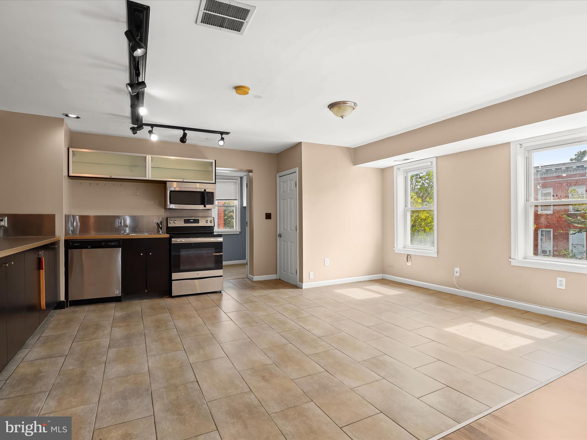 55 South Fulton Avenue Baltimore, MD 21223 - Photo 21 of 55 a large kitchen with stainless steel appliances granite countertop a stove and a sink