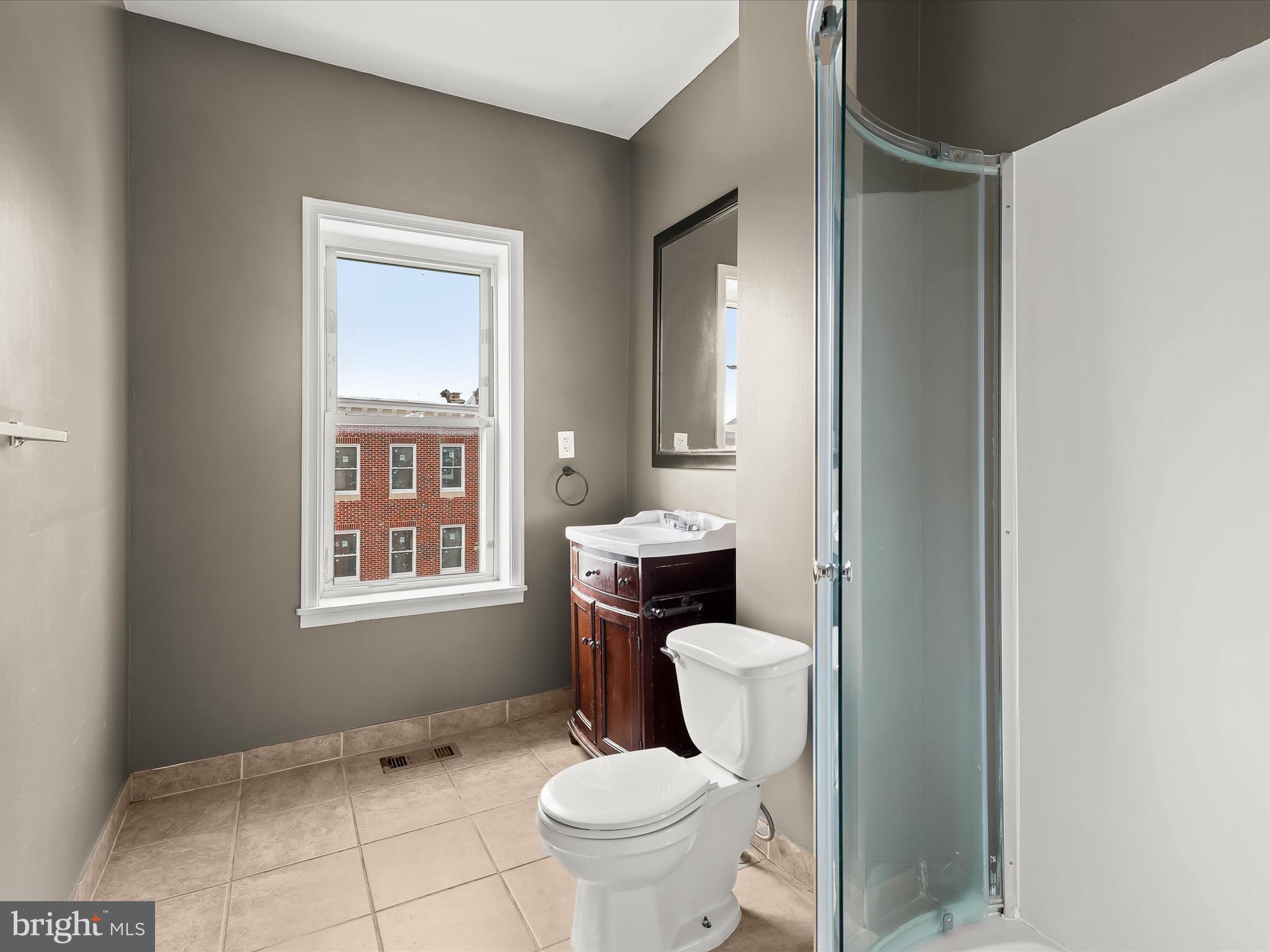 55 South Fulton Avenue Baltimore, MD 21223 - Photo 38 of 55 a white toilet sitting next to a bathroom sink and a window
