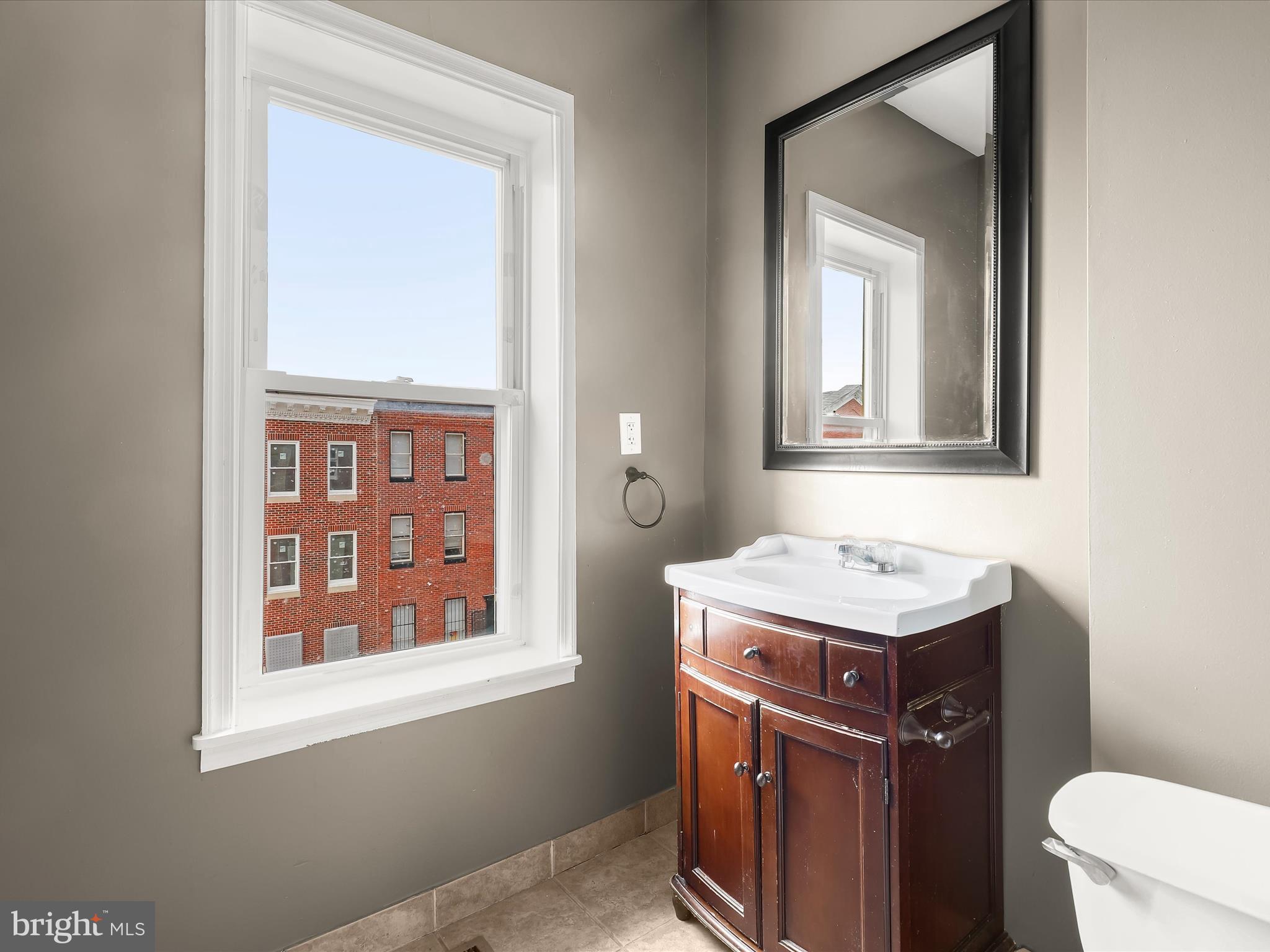 55 South Fulton Avenue Baltimore, MD 21223 - Photo 39 of 55 a bathroom with a sink a toilet and a mirror