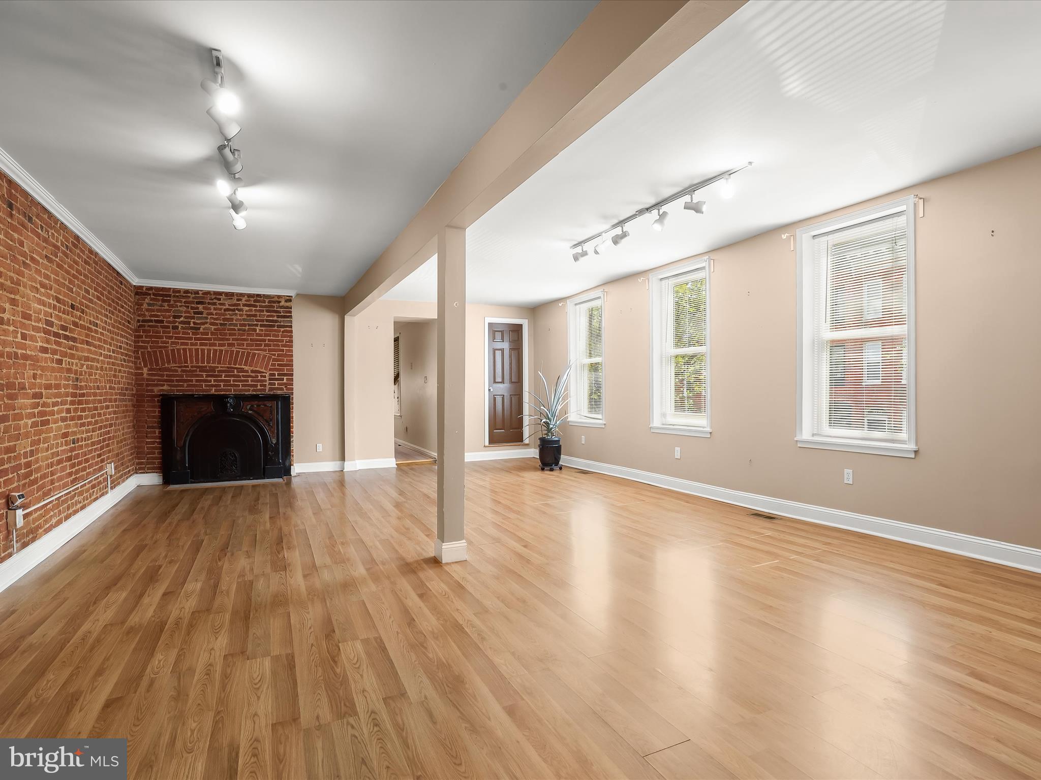 55 South Fulton Avenue Baltimore, MD 21223 - Photo 46 of 55 an empty room with wooden floor fireplace and windows