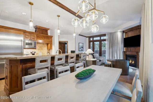 a view of a dining room with furniture a kitchen and chandelier