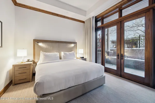 a bedroom with a bed a lamp and a large window