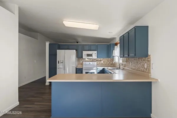 a kitchen with stainless steel appliances granite countertop a refrigerator a sink and a stove