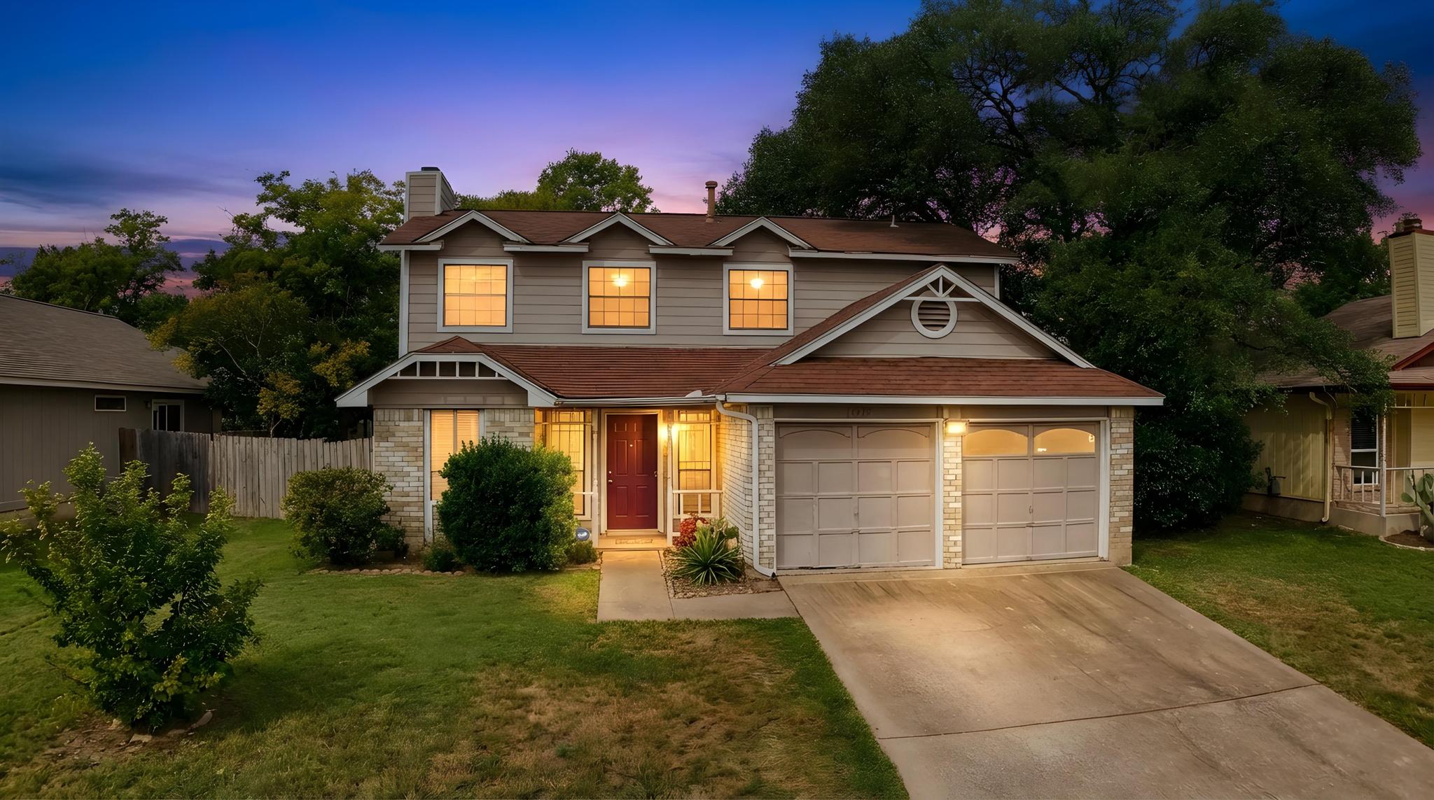 Traditional-style home featuring brick siding, driveway, a chimney, and a garage