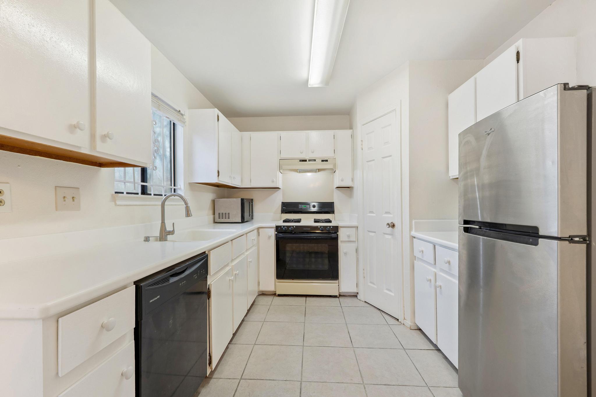 11918 Snow Finch Road Austin, TX 78758 - Photo 14 of 33 Kitchen with appliances with stainless steel finishes, light countertops, and white cabinetry