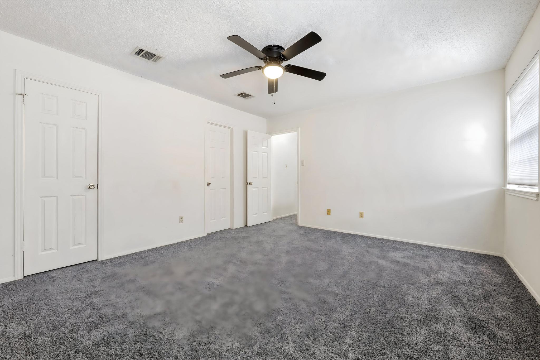 11918 Snow Finch Road Austin, TX 78758 - Photo 21 of 33 Unfurnished bedroom with dark carpet, a ceiling fan, and a textured ceiling
