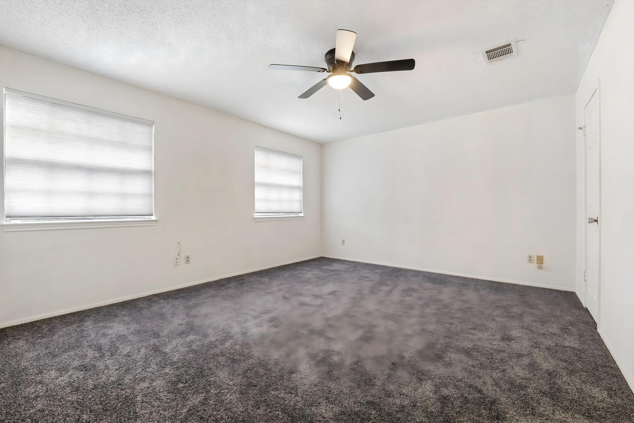 11918 Snow Finch Road Austin, TX 78758 - Photo 23 of 33 Spare room featuring dark carpet and a ceiling fan
