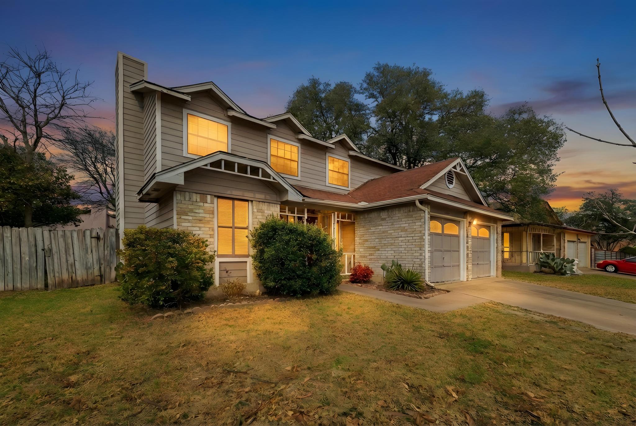 11918 Snow Finch Road Austin, TX 78758 - Photo 3 of 33 View of front of home with concrete driveway, a chimney, and an attached garage