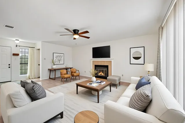 a living room with furniture fireplace and a window
