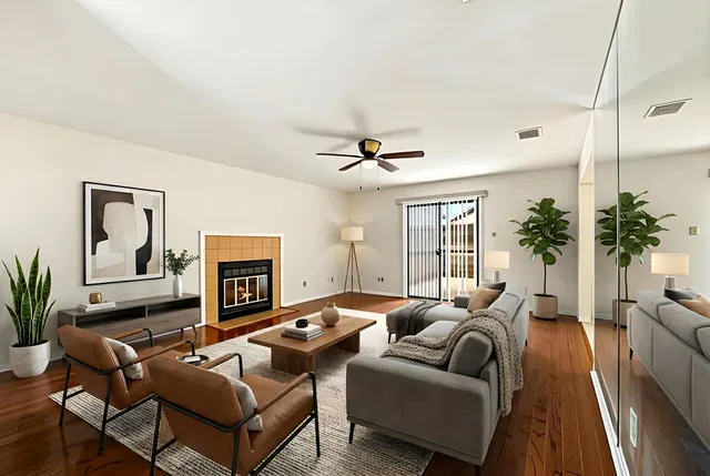 a living room with furniture ceiling fan and a fireplace