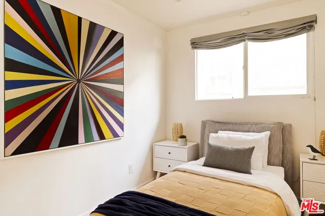 a bedroom with a bed and a large window