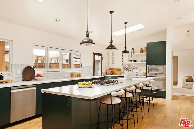 a kitchen with stainless steel appliances kitchen island granite countertop a sink and cabinets
