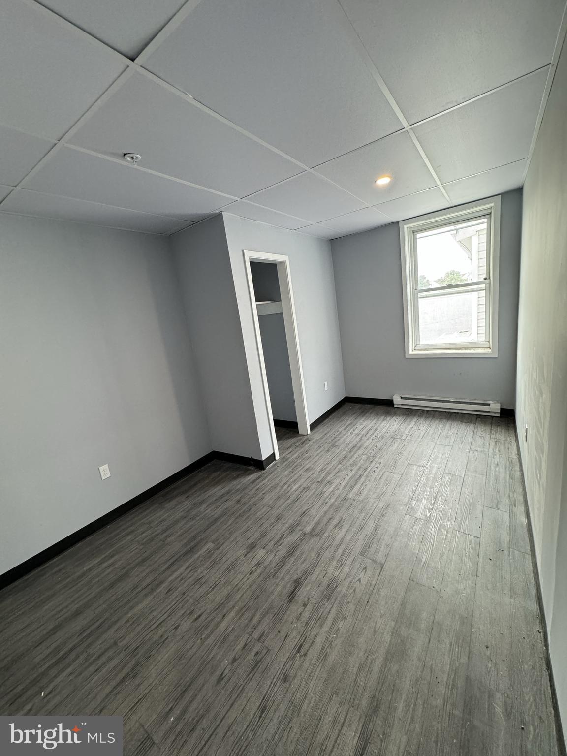 15 Church Lane, Unit 2B Lansdowne, PA 19050 - Photo 5 of 7 an empty room with wooden floor and windows
