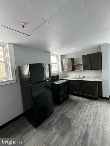 a kitchen with a refrigerator sink and wooden floor