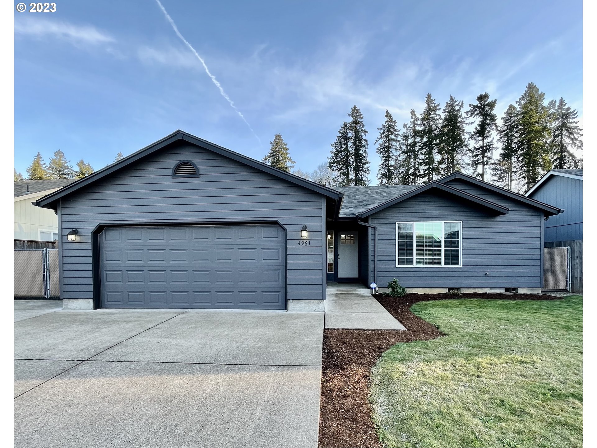 4961 Forsythia Street Springfield, OR 97478 - Photo 1 of 14 a front view of a house with a yard and garage