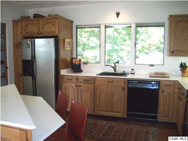 5462 Laurel Ridge Road Charlottesville, VA 22911 - Photo 41 of 50 a kitchen with stainless steel appliances granite countertop a refrigerator a sink a stove with white cabinets