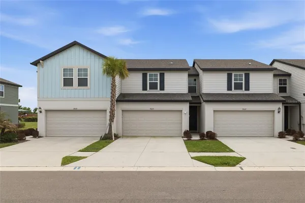a front view of a house with a yard and garage
