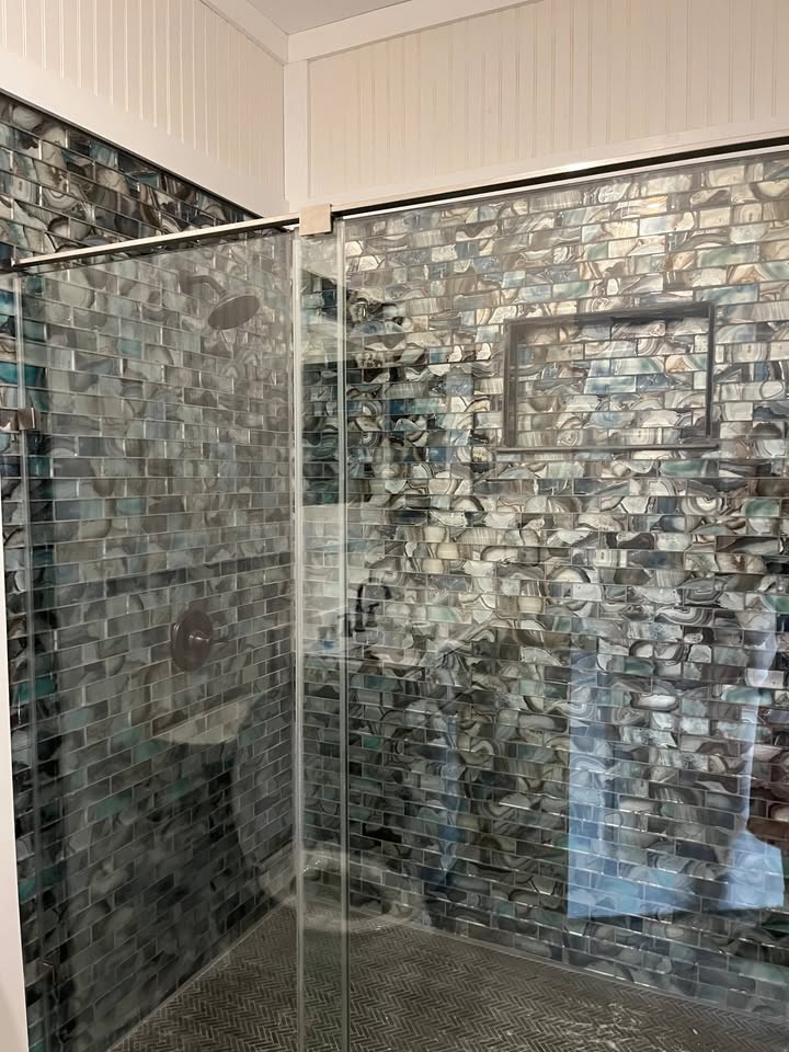 3505 Lone Man Mountain Road, Unit A Wimberley, TX 78676 - Photo 10 of 11 Step into a meticulously tiled shower, featuring a striking accent wall and sleek glass enclosure.