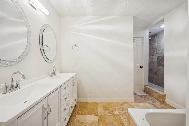 a spacious bathroom with a double vanity sink and a mirror