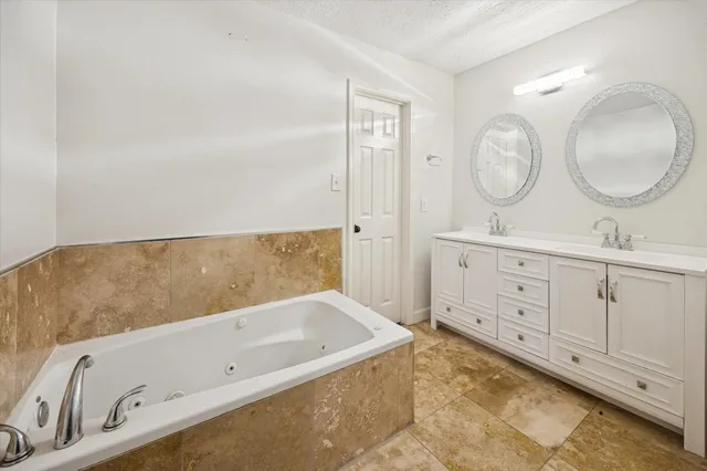 a bathroom with a tub sink and mirror