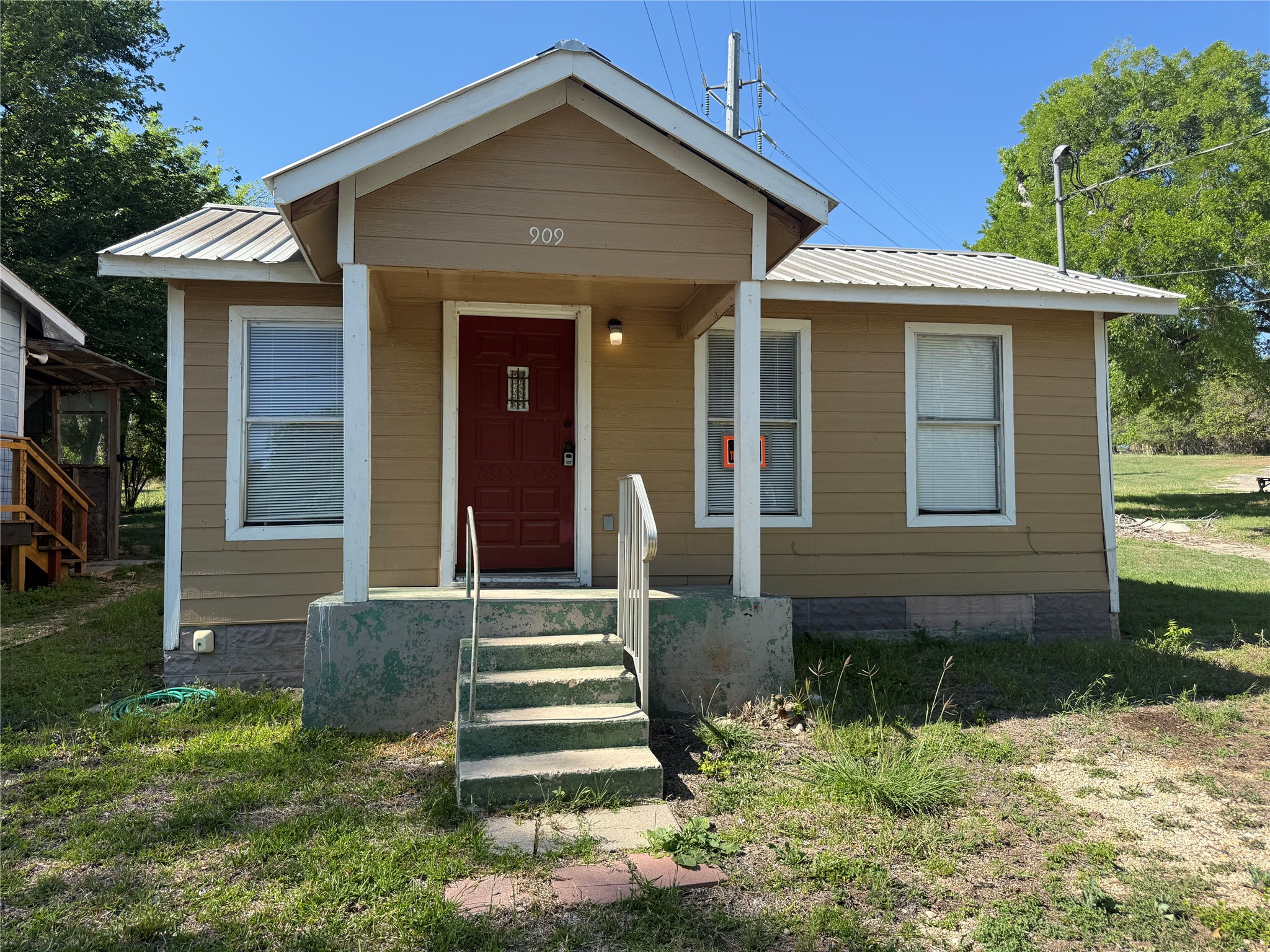 909 East Market Street Lockhart, TX 78644 - Photo 2 of 19 a front view of a house with a yard