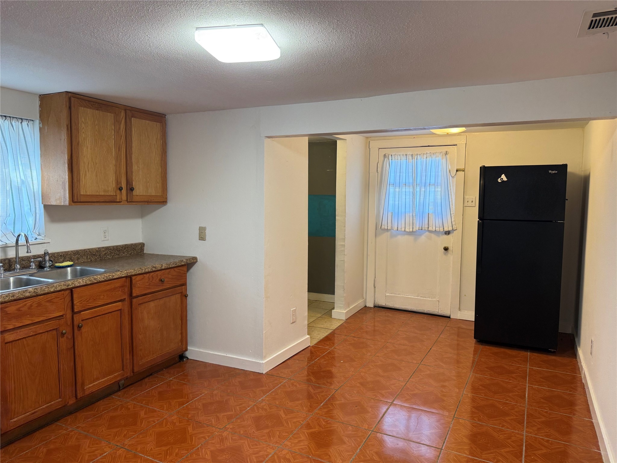 909 East Market Street Lockhart, TX 78644 - Photo 5 of 19 a view of a kitchen with cabinets and refrigerator