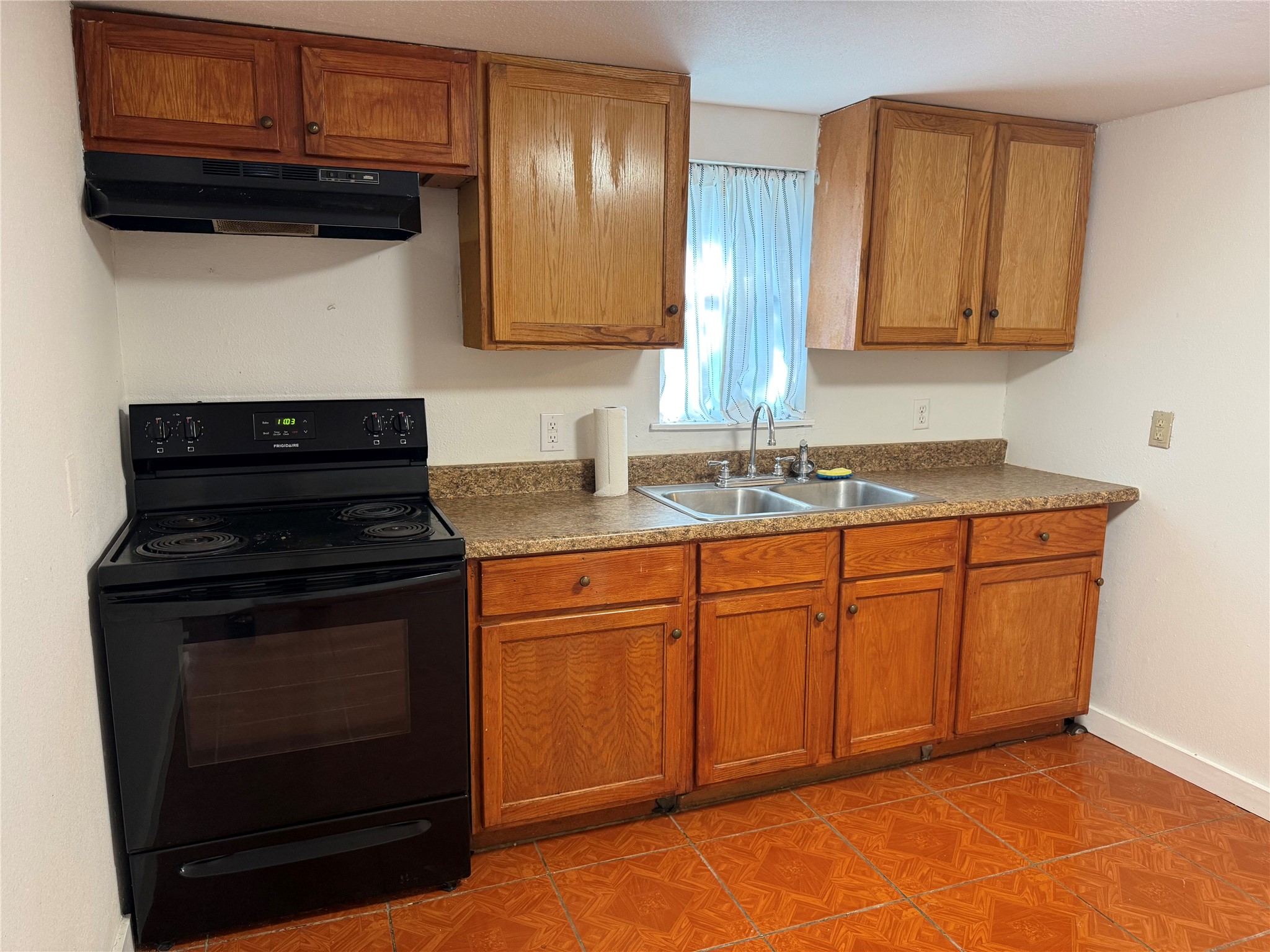 909 East Market Street Lockhart, TX 78644 - Photo 6 of 19 a kitchen with granite countertop wood cabinets and stainless steel appliances