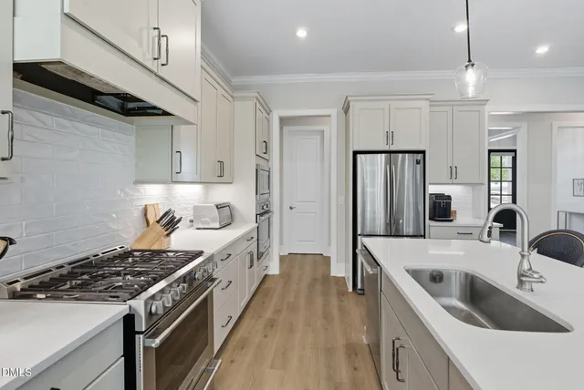 a kitchen with white cabinets and stainless steel appliances