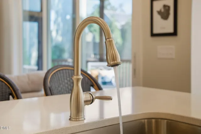 a kitchen with a sink a counter top space a large window and stainless steel appliances
