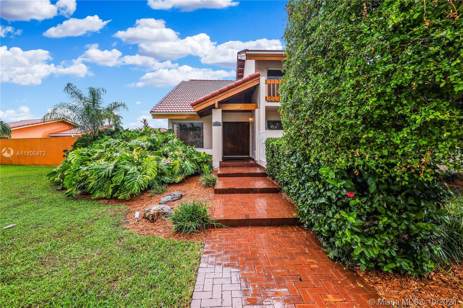 330 Southwest 133rd Place Miami, FL 33184 - Photo 2 of 51 a pathway of a house with potted plants and a yard