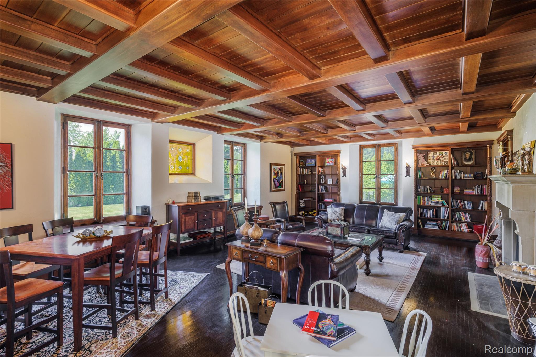 189 Cloverly Road Grosse Pointe, MI 48236 - Photo 16 of 93 A library designed for reflection. One of two libraries within the home, this inviting retreat is distinguished by its beautifully crafted coffered wood ceiling, limestone fireplace, built-in bookcases, and expansive garden views. Designed for reading, conversation, and quiet moments alike, it offers a warm counterpoint to the home’s grand entertaining spaces.