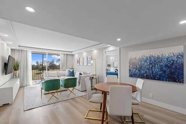 a living room with furniture a large window and dining table