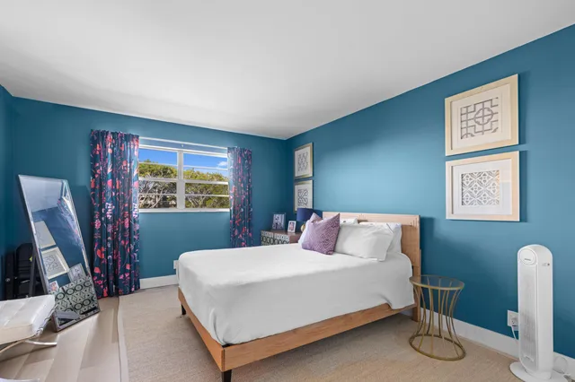 a bedroom with a large bed and a flat tv screen on dresser