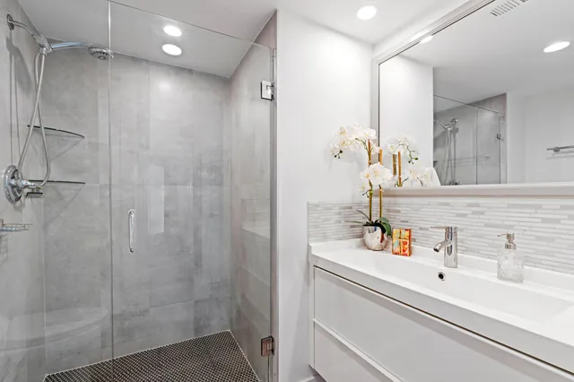 a bathroom with a sink vanity and shower