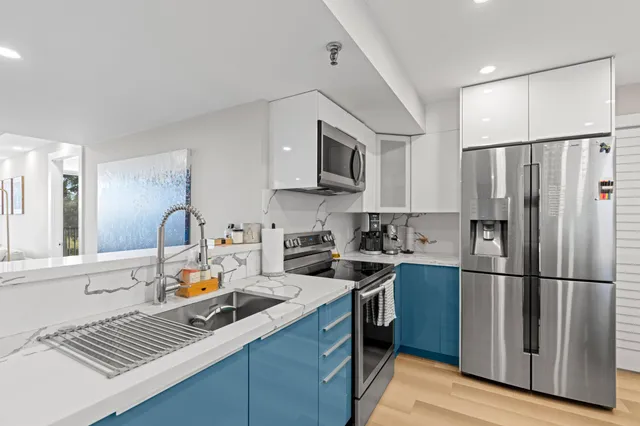 a kitchen with stainless steel appliances granite countertop a refrigerator sink and stove