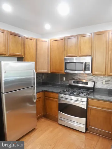 a kitchen with granite countertop a sink and a wooden cabinets