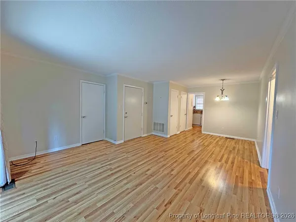 a view of empty room with wooden floor