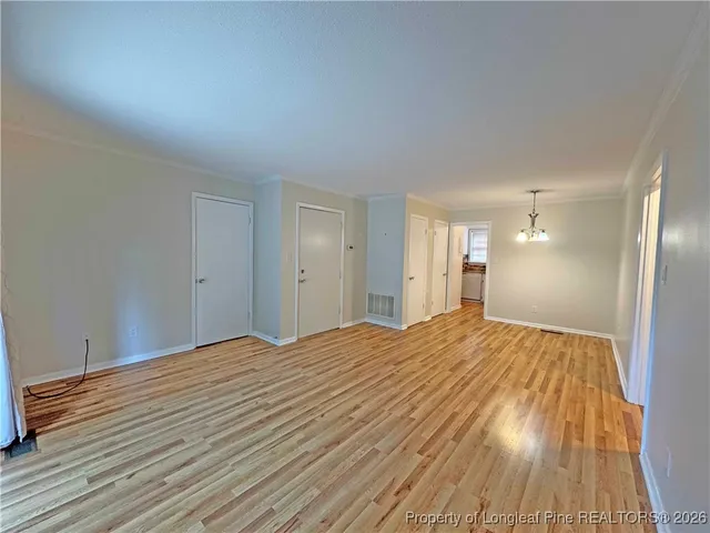 a view of empty room with wooden floor
