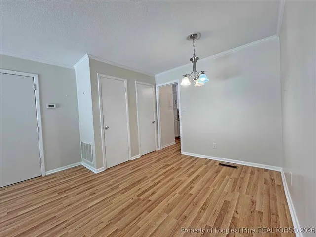 a view of a room with wooden floor and ceiling fan