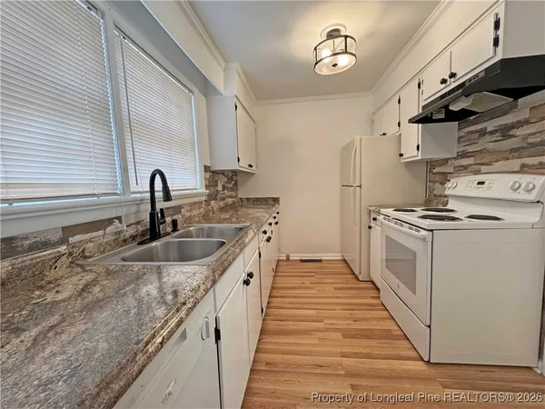 a kitchen with sink a stove and cabinets