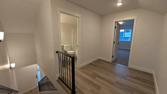 an empty room with wooden floor and entrance