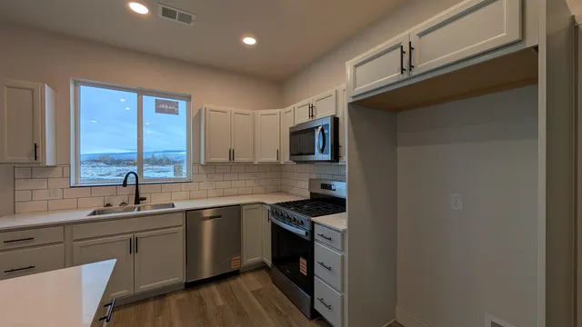 a kitchen with a sink cabinets and stainless steel appliances