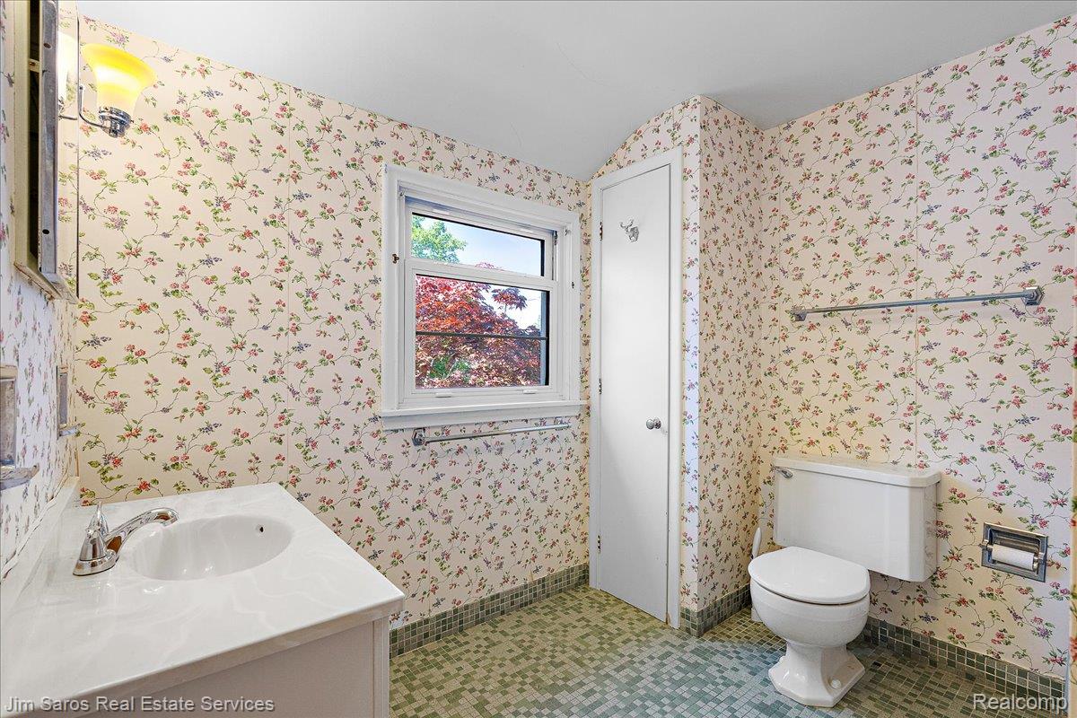 1010 Nottingham Road Grosse Pointe, MI 48230 - Photo 18 of 30 Bathroom featuring a white vanity with an integrated sink, chrome faucet, and a window with exterior views