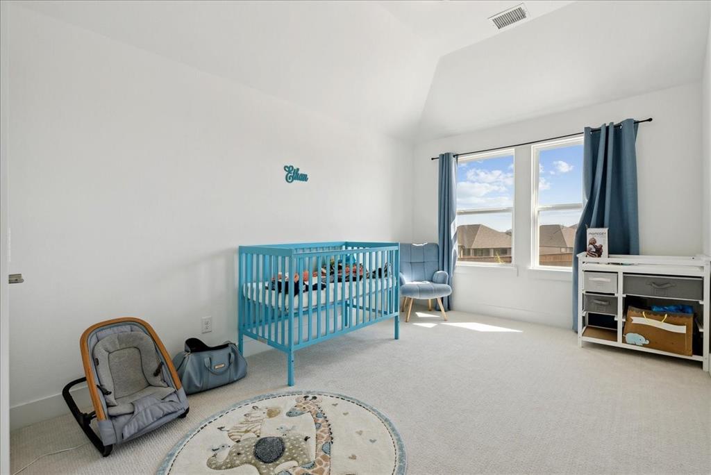 1710 Highwood Road Forney, TX 75126 - Photo 23 of 25 Bright room featuring white walls, a vaulted ceiling, and light-colored carpet flooring
