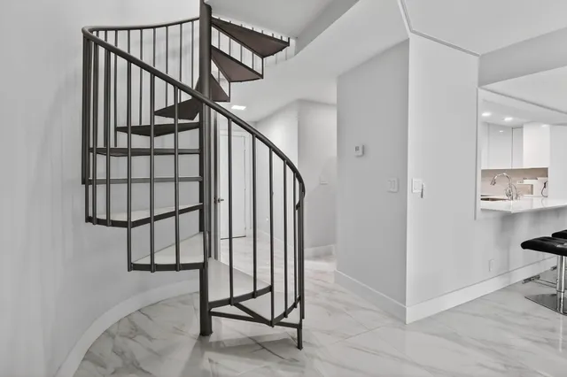 a view of staircase with white walls and a window