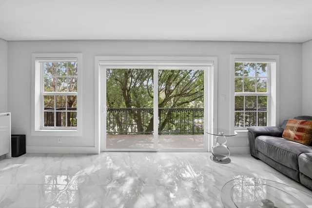a view of a livingroom with furniture and floor to ceiling window