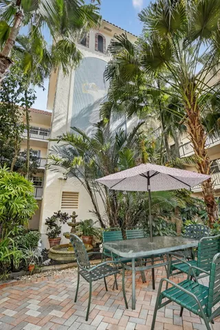 a palm tree sitting in front of a house with a yard